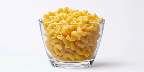 Aufkleber - Raw macaroni pasta displayed in a clear glass bowl against a plain white background with a pile of vibrant yellow curved shapes inside.