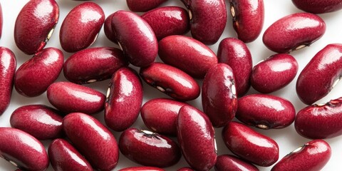 Poster - Red kidney beans scattered on a clean white background showcasing their vibrant wine-red color and smooth glossy texture in a natural arrangement