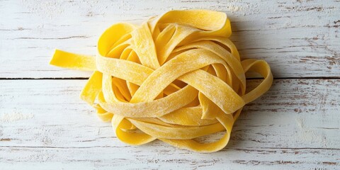 Poster - Fresh raw tagliatelle pasta arranged in a circular pile on a textured white wooden surface with soft natural lighting highlighting the yellow hues