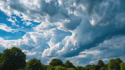 Aufkleber - Dramatic summer clouds against a blue sky with lush green trees in a serene landscape under natural sunlight