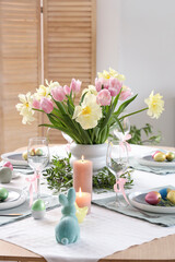 Wall Mural - Festive Easter table setting with vase of flowers, cutlery, candles and painted eggs