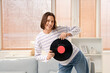 © Pixel-Shot - Young woman with vinyl disk dancing at home