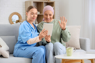 Wall Mural - Mature woman after chemotherapy with nurse video chatting on sofa at home. Brain cancer concept