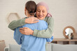 © Pixel-Shot - Mature woman after chemotherapy with nurse hugging at home. Brain cancer concept