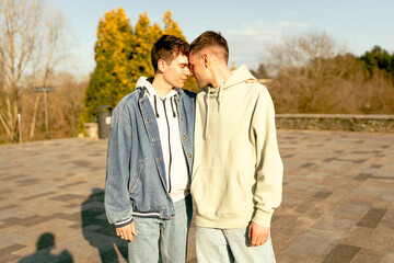 Young gay couple sharing intimate moments in urban park