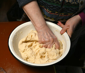 Woman skillfully kneading dough using  hands, focusing on the texture and consistency