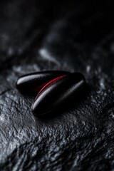 Canvas Print - Close-up of sleek black objects with a red accent on a dark surface.