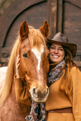 Wall Mural - A beautiful adult woman and her brown horse cuddle and interact together, equestrian team scene