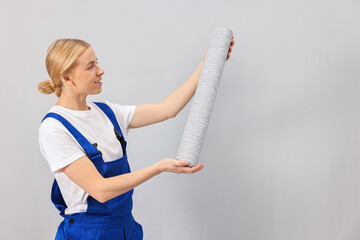 Wall Mural - Smiling worker with roll of wallpaper indoors, space for text