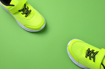 New green sneakers on a green background.