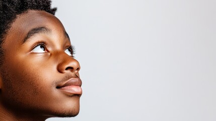 Wall Mural - The image shows a young person gazing off to the side, with a thoughtful expression.