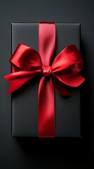 Wall Mural - Elegant Black Gift Box Adorned With a Red Satin Ribbon, Perfect for Celebrations or Special Occasions