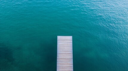 Poster - A scenic aerial view of a wooden dock extending into tranquil blue waters surrounded by nature : Generative AI