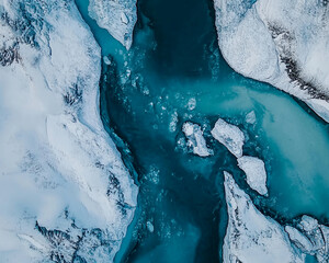 Poster - Aerial view of a frozen river cutting through snow and ice, showcasing the contrast between the vibrant blue water and icy landscape, symbolizing nature's power and winter beauty.