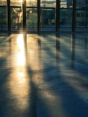 Poster - A bright and reflective scene showcasing sun rays streaming across a polished floor with beautiful shadows cast : Generative AI