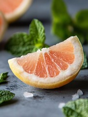 Poster - Fresh and vibrant slice of grapefruit with mint leaves on a textured gray surface : Generative AI