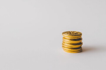 Poster - Pile of golden Bitcoin coins on a white background, representing cryptocurrency and digital finance, a modern investment concept. Coin stack symbolizing wealth and financial technology.