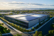 © Jack - Aerial view of modern data center facility exterior, with solar panels on the roof and green space around it. The building is large in size, featuring sleek grey metal cladding and glass windows
