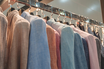Poster - A rack of clothes with a variety of colors and styles. The clothes are hanging on a metal rack, and the colors include blue, pink, and brown
