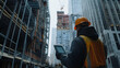© Abdul - Safety-geared technician cross-checking building progress via digital device at mid-rise site