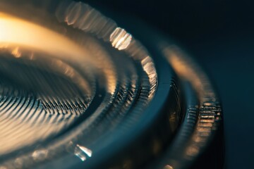 Poster - An abstract close-up of a textured metallic surface with intricate patterns and warm light, showcasing a modern and industrial aesthetic with a touch of elegance.