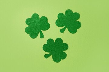 St. Patrick's day with three clover leaves on green background. Greeting card. View from above.