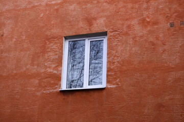 Aufkleber - A window on a red building with a tree reflected in the window.