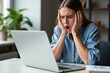 © SimpleDesignStudio - Stressed Young Woman in Casual Blue Shirt Reacts with Distress While Using Laptop in Modern Workspace Surrounded by Green Plants