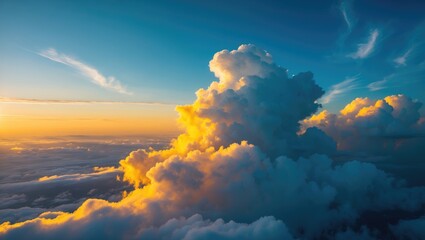 Wall Mural - Aerial perspective reveals a stunning golden sunrise over dense, white clouds under a blue sky.