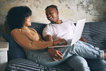 Poster - Laugh, home and couple on sofa with laptop for online shopping, internet and digital subscription. Living room, happy and African man with woman on computer for website, videos and movies on weekend