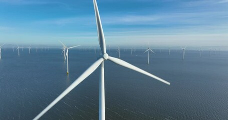 Poster - Drone footage of a wind energy turbine on water against a clear blue sky