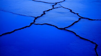 Poster - Cracked Surface of Ice with Deep Blue Tones in Winter Nature Scene