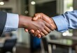 © AMINE - Two people shaking hands. One is wearing a blue shirt. The other is wearing a black shirt