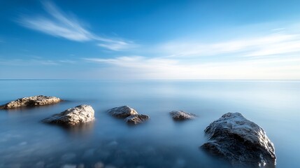 Poster - Serene Coastal Scene with Smooth Rocks Under a Tranquil Blue Sky and Calm Water Surface : Generative AI