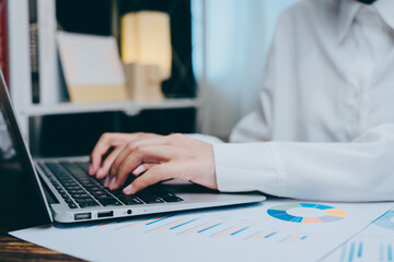 Poster - Professional Hands Typing on Laptop Near Business Charts and Papers, business concept