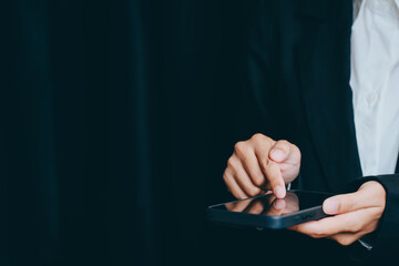 Poster - person using tablet device with dark background in business attire, business concept