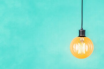 Light bulb hanging turquoise background