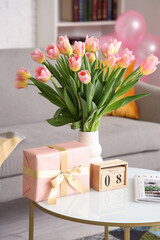 Wall Mural - Calendar with date of International Women's Day, tulips and gift box on table in living room