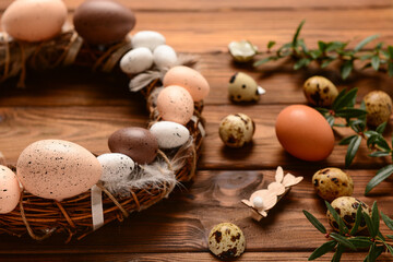 Wall Mural - Stylish Easter wreath decorated with  eggs and feathers on wooden background.