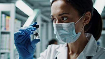 Poster - Medical professional in protective gear carefully examining coronavirus vaccine vial, showcasing scientific research and healthcare innovation in slow motion laboratory setting