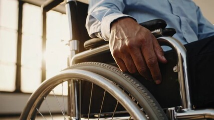 Aufkleber - Sunlight illuminates businessman's hand resting on his wheelchair, conveying themes of disability, accessibility, and inclusion in the workplace