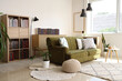 © Pixel-Shot - Green sofa and bookshelves with many books in living room