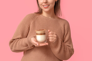 Wall Mural - Young woman with glass cup of hot coffee on pink background