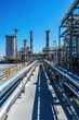 © wpw - Vast industrial gas processing facility featuring massive storage tanks and intricate pipelines under a clear blue sky.