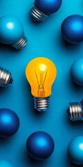 Poster - A vibrant yellow light bulb stands out among blue bulbs, symbolizing innovation and creativity.