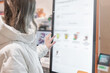 © Vladimir Razgulyaev - A woman in a white jacket chooses drinks and orders food for dessert in a restaurant or pizzeria coffee shop through a touchscreen screen on her own. The restaurant menu is displayed on the screen in