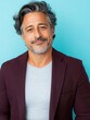 © SerPak - Confident hispanic mature male smiling in smart casual attire against blue background.