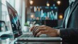 © auttawit - Man is typing on a laptop in front of a monitor with graphs on it