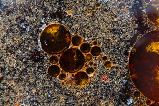 Close up macro shot of fat globules, fat droplets or grease spots in a frying pan - texture for computer graphics cgi, compositing and creative design