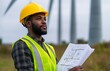 © yevgeniya131988 - African American engineer holding blueprints near wind turbines outdoors